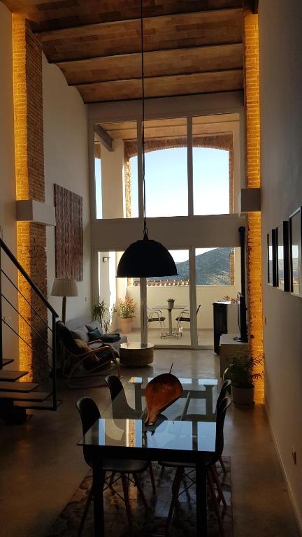 ein Wohnzimmer mit einem Tisch und einem großen Fenster in der Unterkunft Loft Mariola - Apartamento en el centro histórico in Bocairent