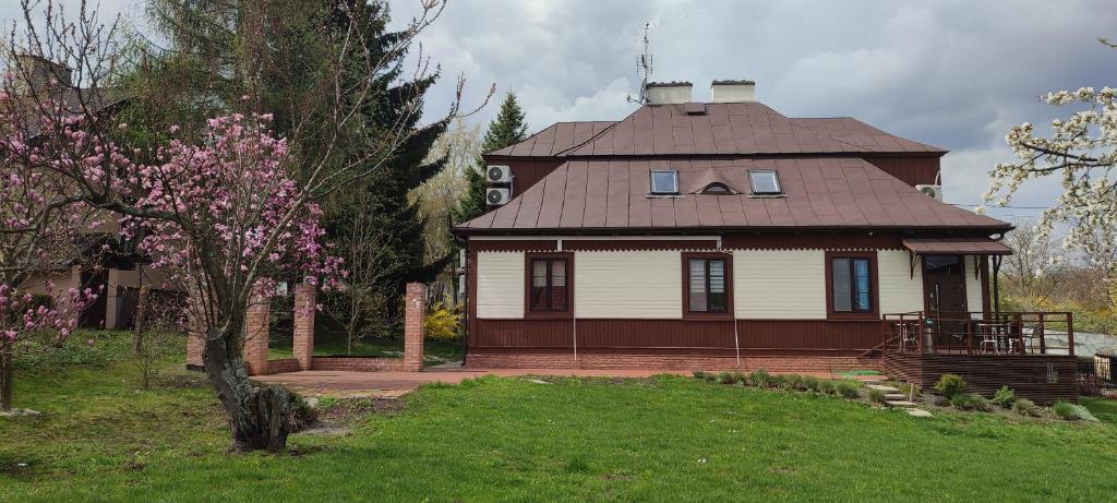 ein Haus mit einem braunen Dach und einem Baum in der Unterkunft Willa Milonga in Sandomierz