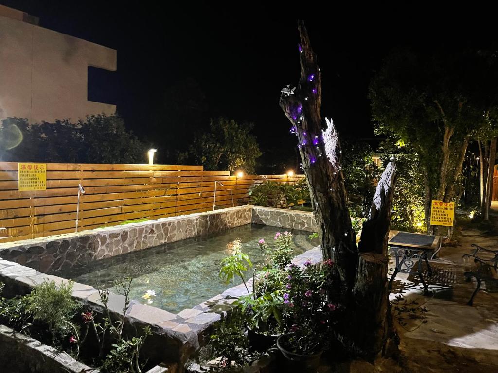 a swimming pool in a garden at night at 寧靜的家14人Villa獨立設施包棟戲水池烤肉區麻將廚房私人停車場 in Hengchun South Gate