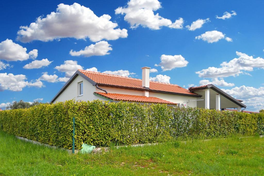 a house with a hedge in front of a house at House Fazana 2154 in Fažana