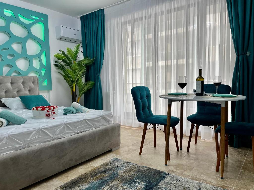 ein Schlafzimmer mit einem Bett, einem Tisch und Stühlen in der Unterkunft Bakuba - Studio pe plaja cu vedere la mare & loc parcare gratis in Mamaia Nord – Năvodari