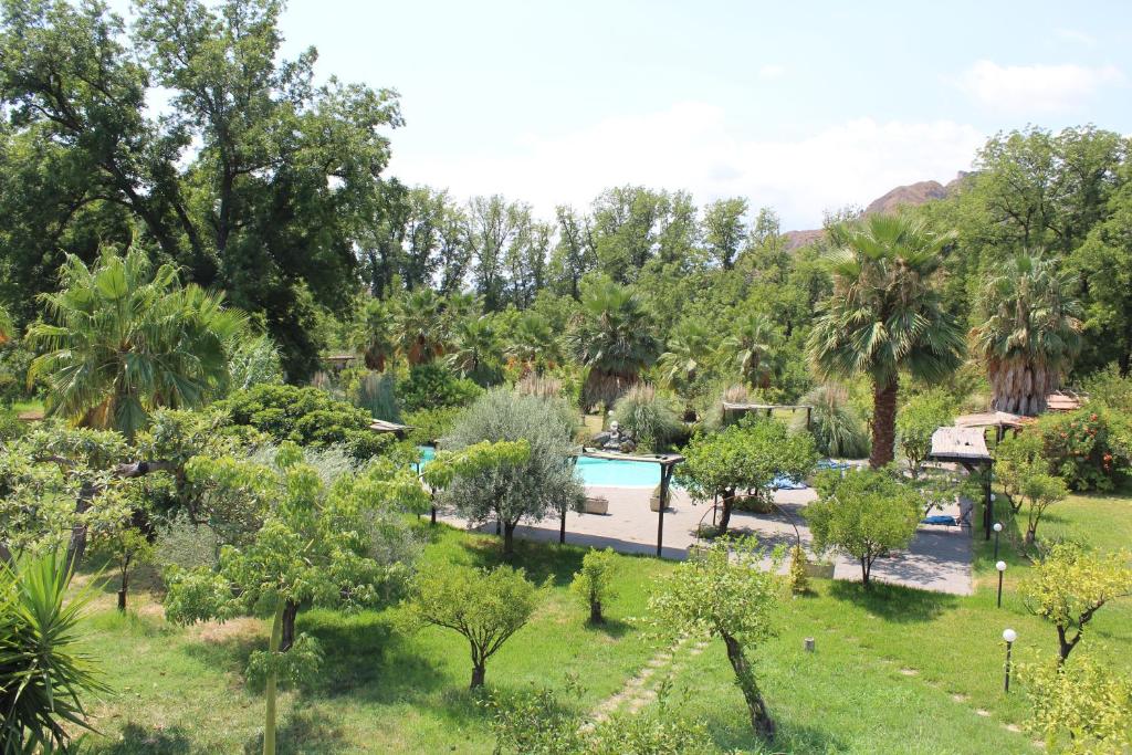 uitzicht op een park met een zwembad en bomen bij Villa Piersepp B&B in Trappitello