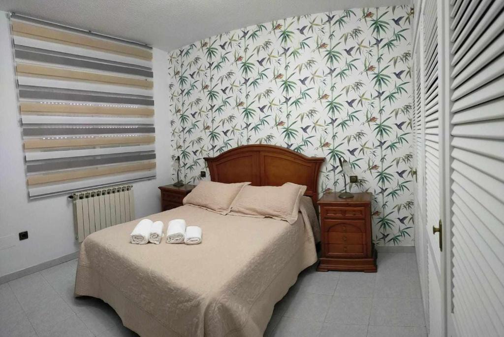 Un dormitorio con una cama con dos zapatos. en Ideal FAMILIAS hasta 15 Personas en San Martín de Valdeiglesias Madrid en San Martín de Valdeiglesias