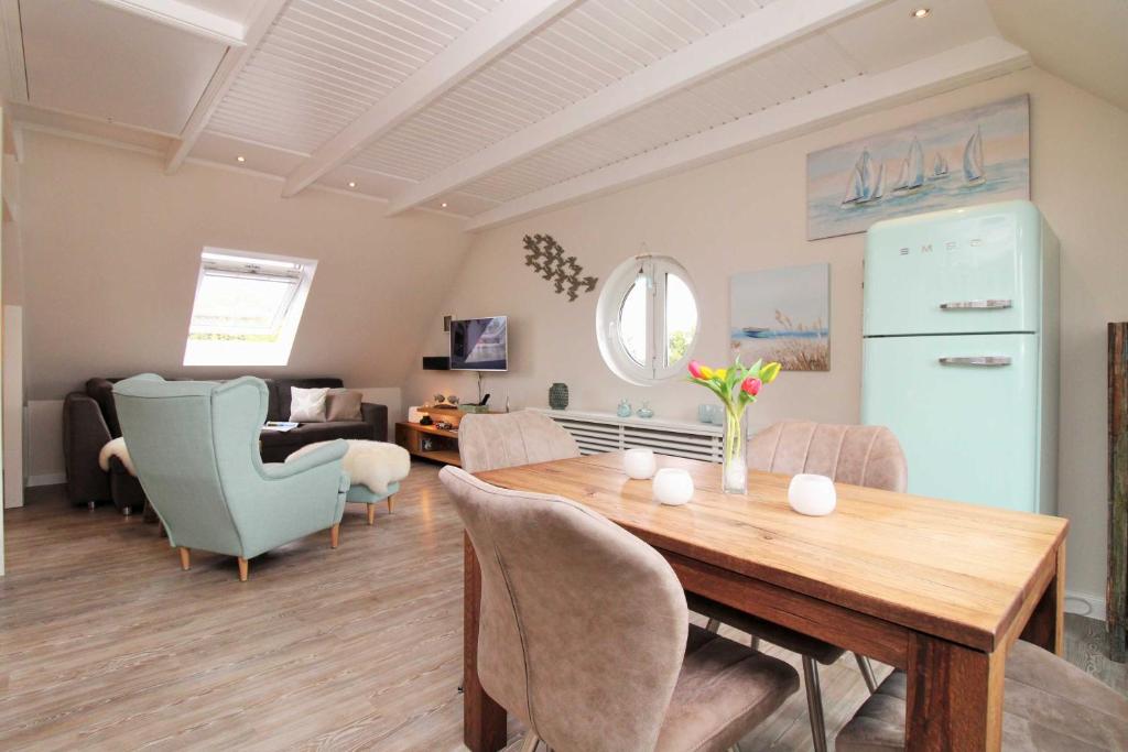 eine Küche und ein Wohnzimmer mit einem Tisch und Stühlen in der Unterkunft Appartementhaus Ulmenhof Fewo 11 in Kühlungsborn