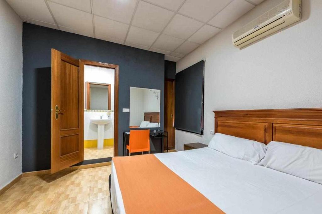 1 dormitorio con 1 cama y baño con lavamanos en KubiK HOTEL, en Cáceres