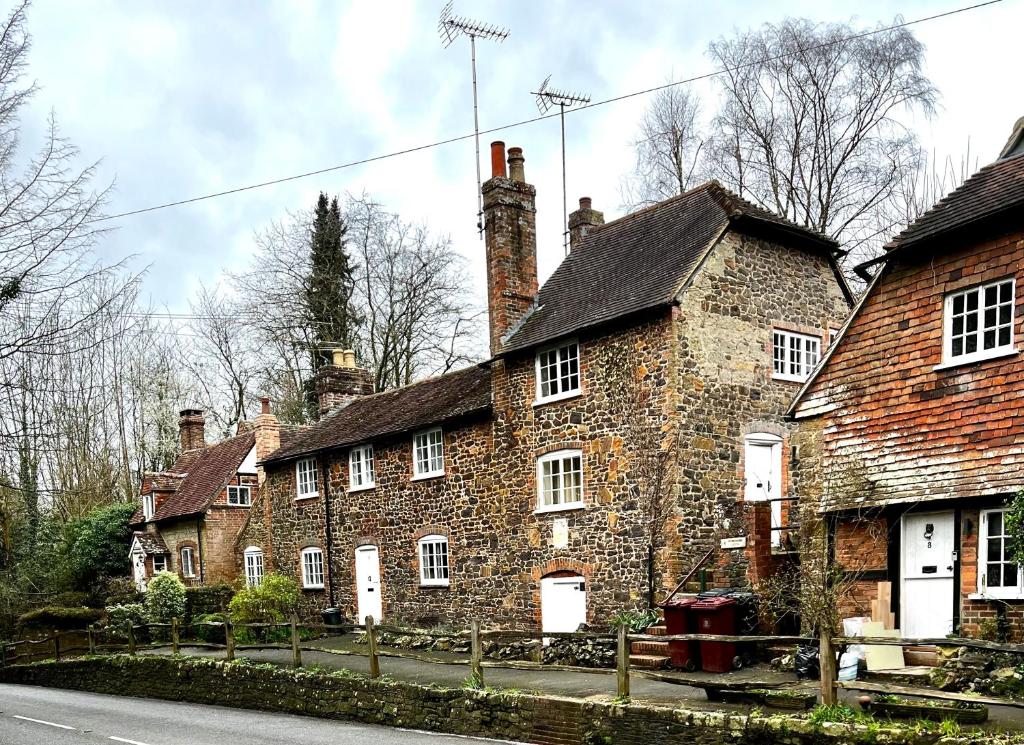 um grupo de casas antigas de tijolos do lado de uma rua em 4 St Richard’s Cottages em Fittleworth