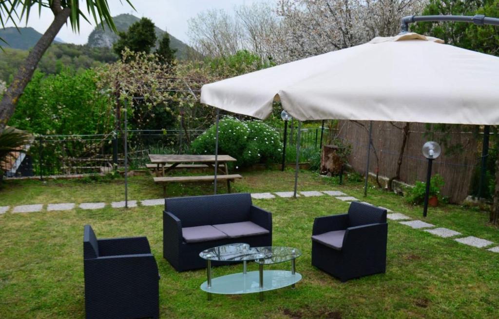 zwei Stühle und ein Tisch unter einem Schirm in der Unterkunft Casaventre in Vietri