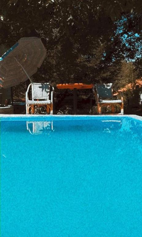 two chairs and a table in a swimming pool at Relax house in Visoko