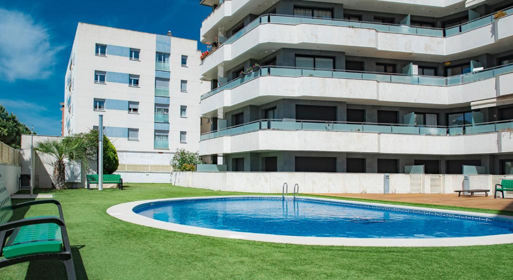 un edificio con piscina frente a un edificio en Parrot`s House Fenals, en Lloret de Mar