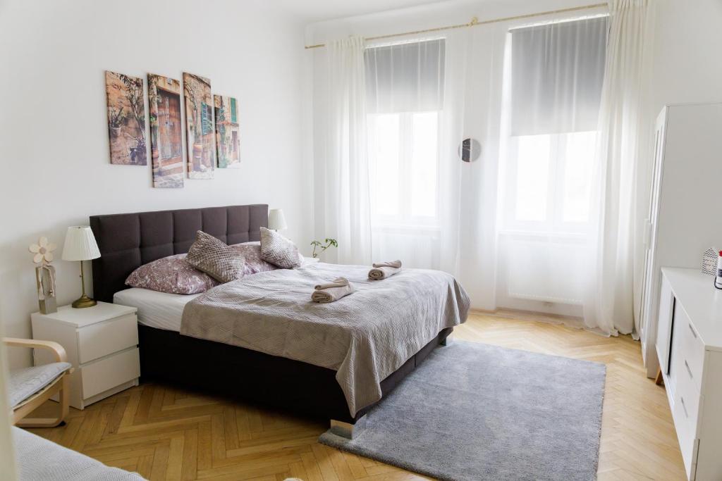 ein weißes Schlafzimmer mit einem Bett und einem Teppich in der Unterkunft Moonlight apartment with porch near Schönbrunn and Westbahnhof in Wien