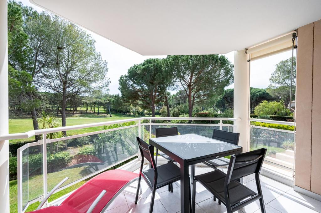 a patio with a table and chairs on a balcony at Le Drive in Saint-Raphaël