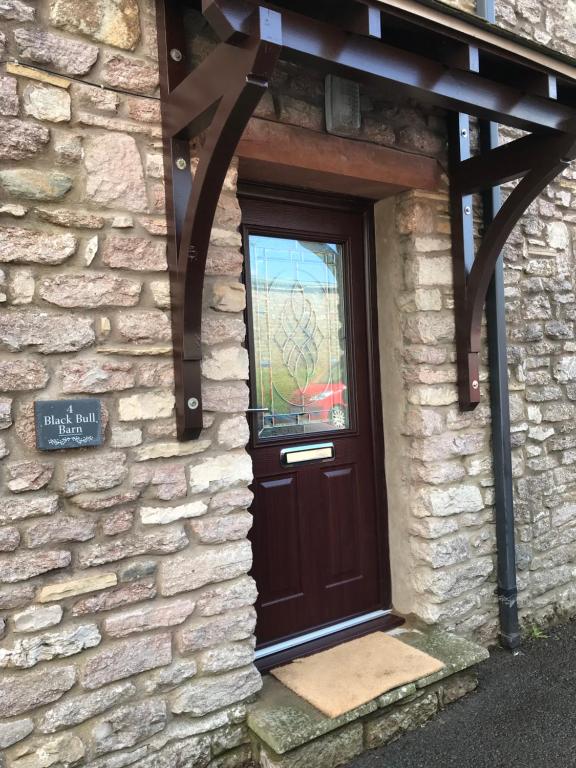 a door of a stone building with a window at Black Bull Barn in Kirkby Stephen