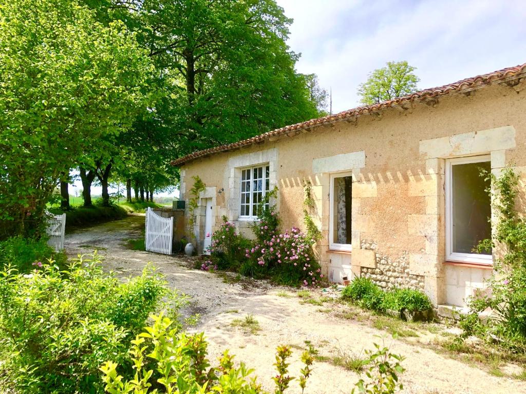 una antigua casa de piedra en un jardín en As seen on A New Life in The Sun - Beautiful 3 bedroom cottage with shared pool, en Montboyer