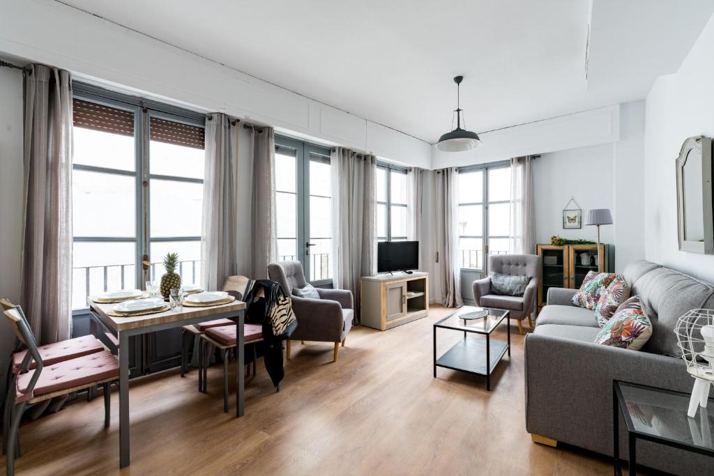 a living room with a couch and a table at Apartamentos RG Suites Sierpes 54 in Seville