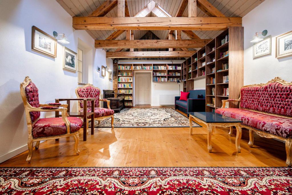 a living room with a table and chairs and bookshelves at HoStel Cosmopolitan* in Banská Štiavnica