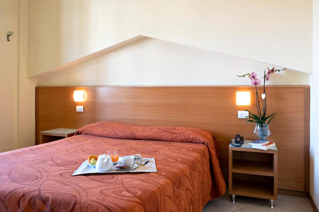 a hotel room with a bed with a tray of food on it at Hotel Mirage in Viareggio