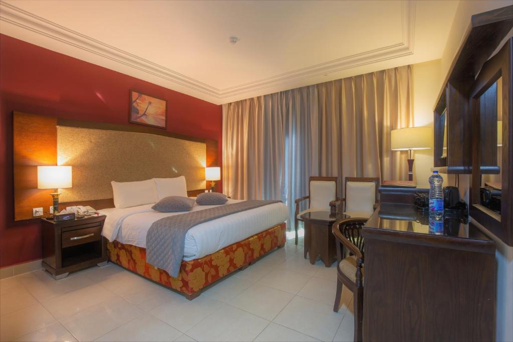 a hotel room with a bed and a desk at Petra Moon Hotel in Wadi Musa