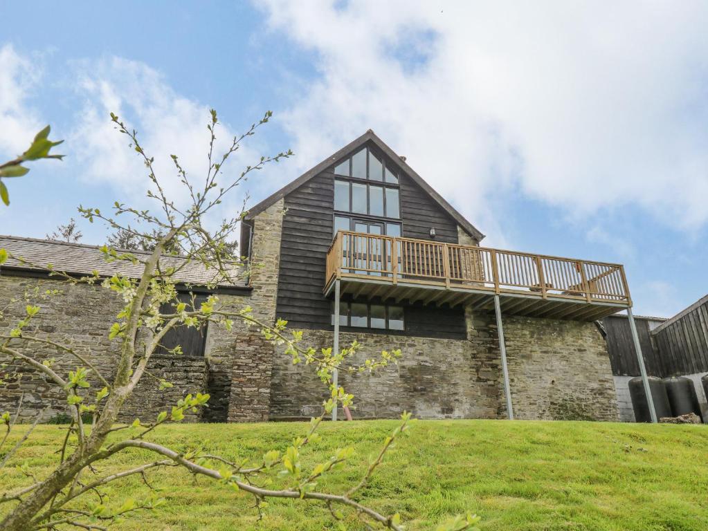 a house with a deck on the side of it at Goblaen Barn in Builth Wells