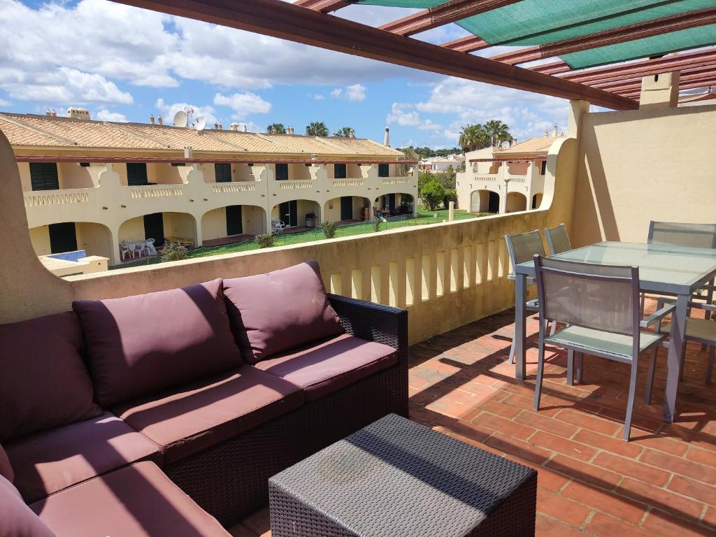 a patio with a couch and a table on a balcony at 51 VilaMar - Casas & Papeis in Porches