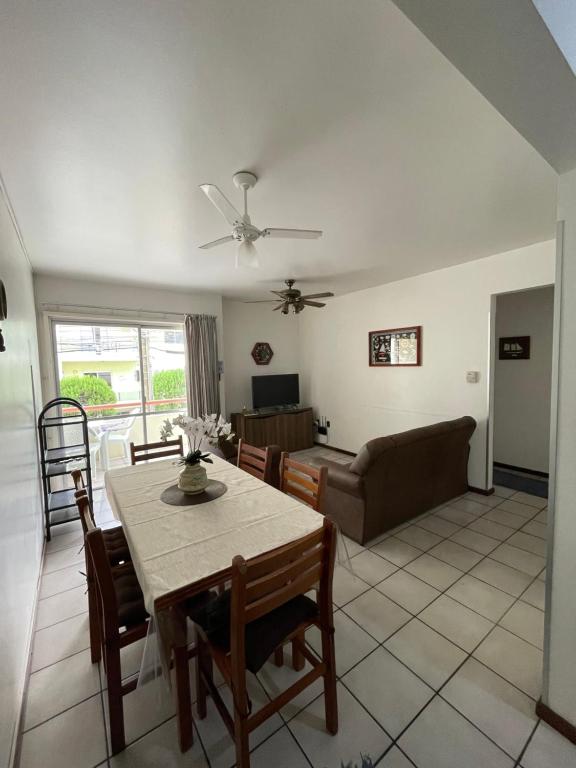 a living room with a table and a couch at Lindo apartamento super completo em Meia Praia, 100 metros do mar e 10 quadras do centro in Itapema