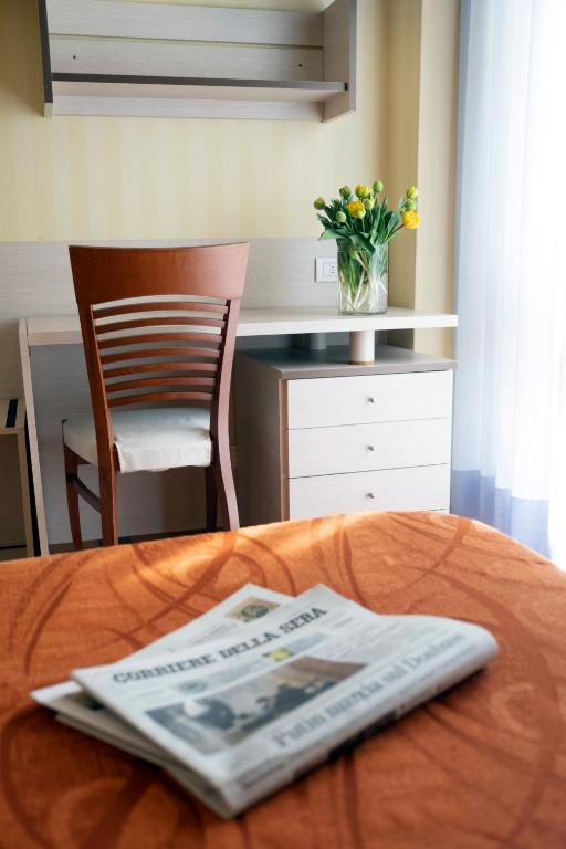 a table with a magazine on top of a bed at Hotel Mirage in Viareggio