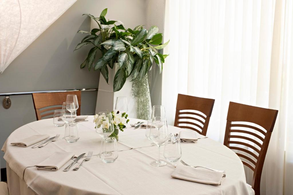 a table with wine glasses and a plant on it at Hotel Mirage in Viareggio