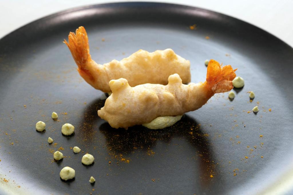 a black plate with a piece of food on it at Hotel Mirage in Viareggio