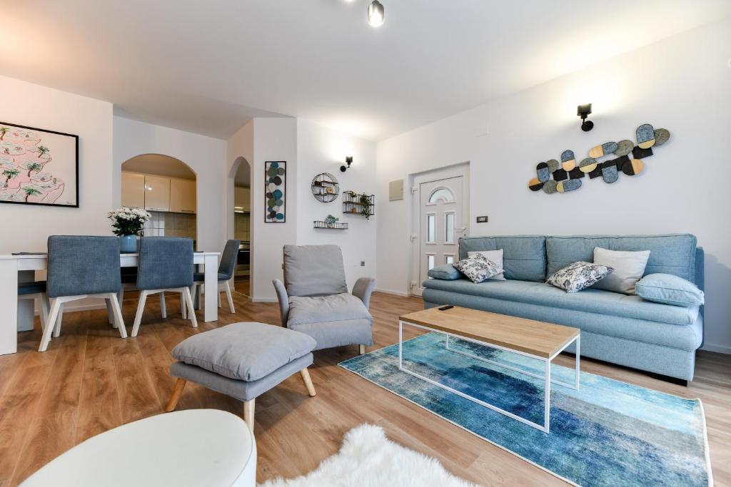 a living room with a blue couch and a table at White Hill Apartment in Zadar