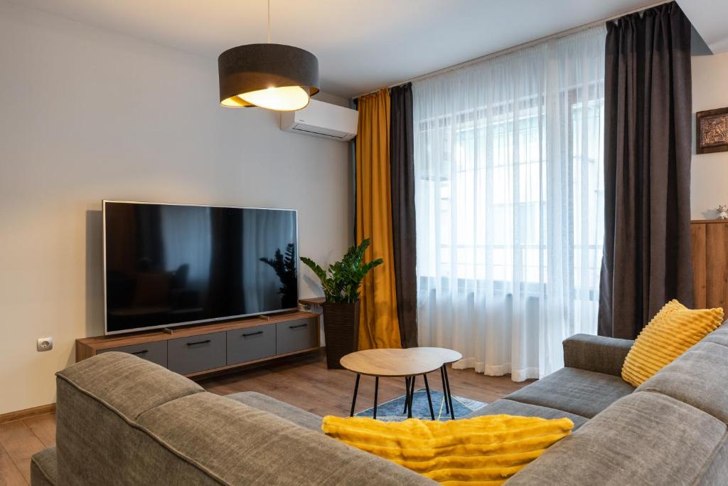 a living room with a couch and a flat screen tv at Апартаменти 22 in Velingrad