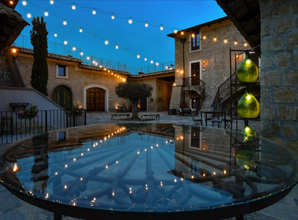 a pool in the middle of a courtyard with lights at Masseria del Carmine Maggiore 1817 in Pozzuoli