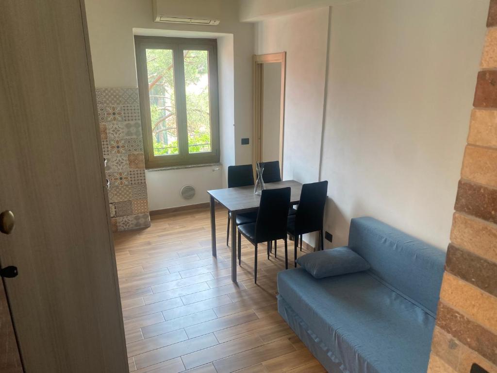 een woonkamer met een blauwe bank en een tafel en stoelen bij CASA CAMILLA in Portovenere