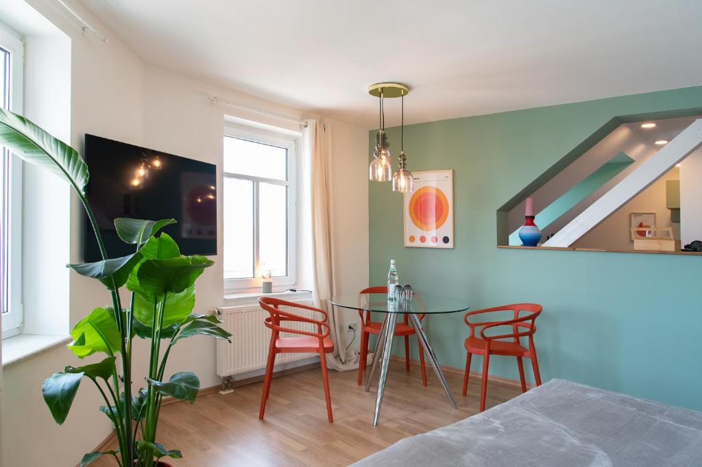 a dining room with a table and red chairs at Bauhaus Apartment - Netflix & Wifi in Chemnitz