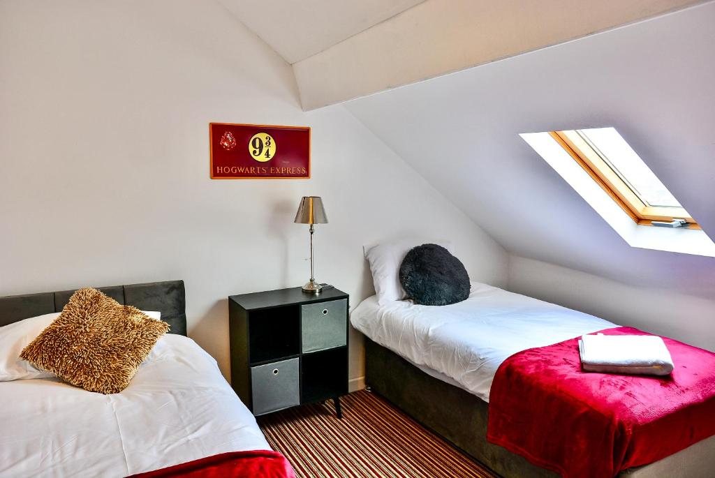a attic bedroom with two beds and a window at Captivating 3-Bed house in Swansea Town center in Swansea