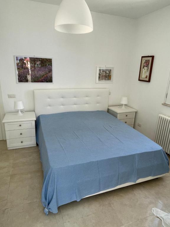 a bedroom with a blue bed and two night stands at Villa Portinente in Lipari