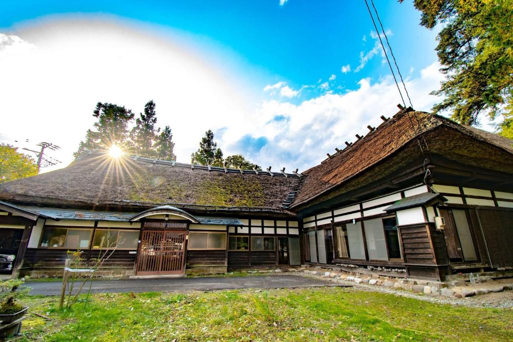 仙北市にあるStay and Discover Nishinoyaの屋根に太陽が輝く古家