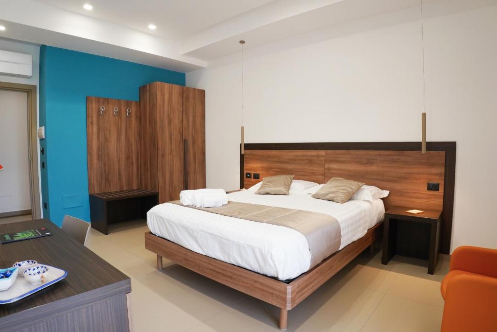 una camera con un grande letto con testiera in legno di Villa Mafalda B&B a Frattamaggiore