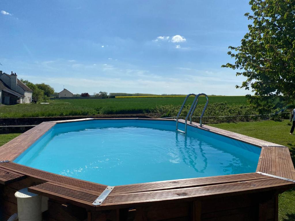 ein Pool mit einer Holzterrasse um ihn herum in der Unterkunft Le Maquis in Charmes