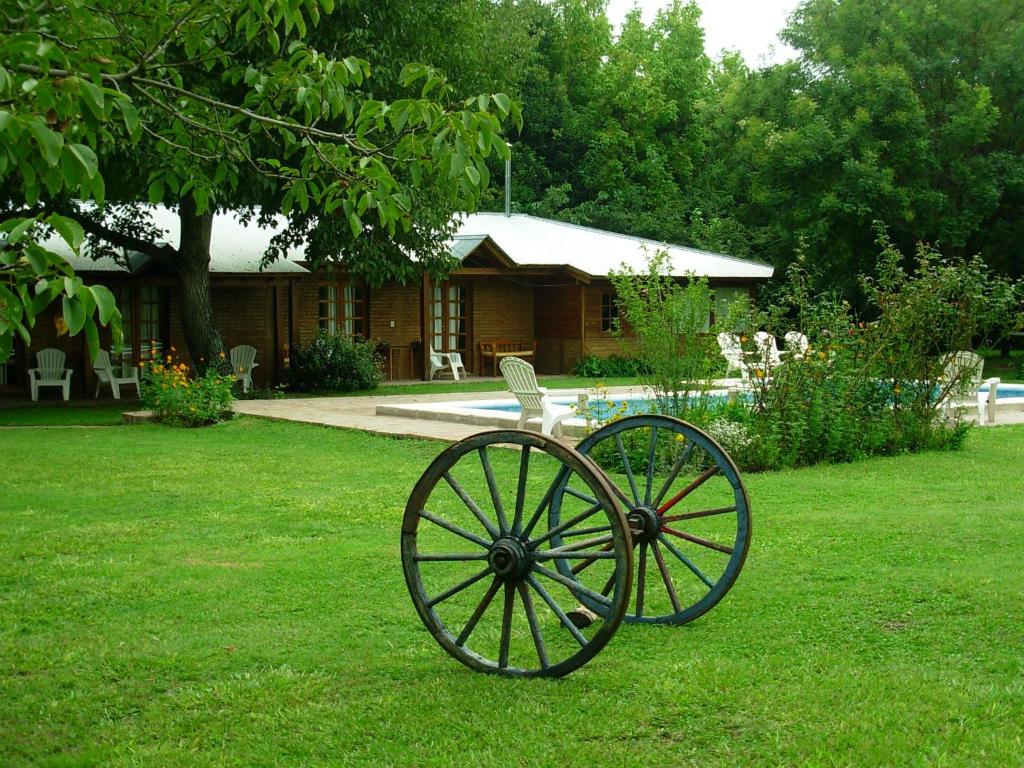 a carriage in the grass in front of a house at Hosteria Rural Piedra y Camino in Nono