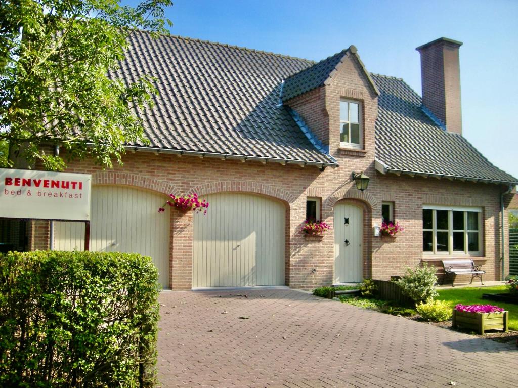 une maison en briques avec un garage dans l'établissement BENVENUTI, à Saint-Idesbald