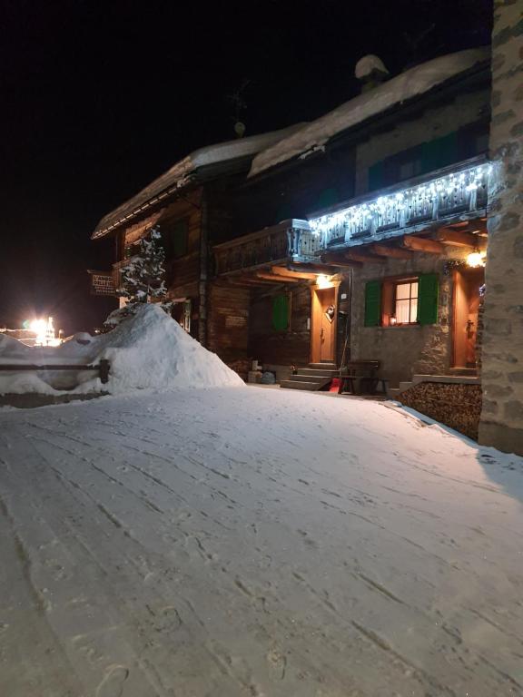 een berg sneeuw voor een gebouw 's nachts bij Chalet Rasia in Livigno