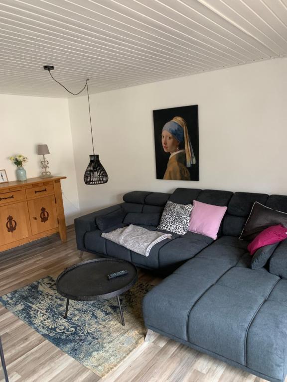 a living room with a blue couch and a table at Ferienwohnung Lara in Ludwigswinkel