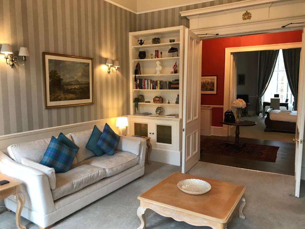 a living room with a couch and a table at Escape To Edinburgh @ Albyn Place in Edinburgh