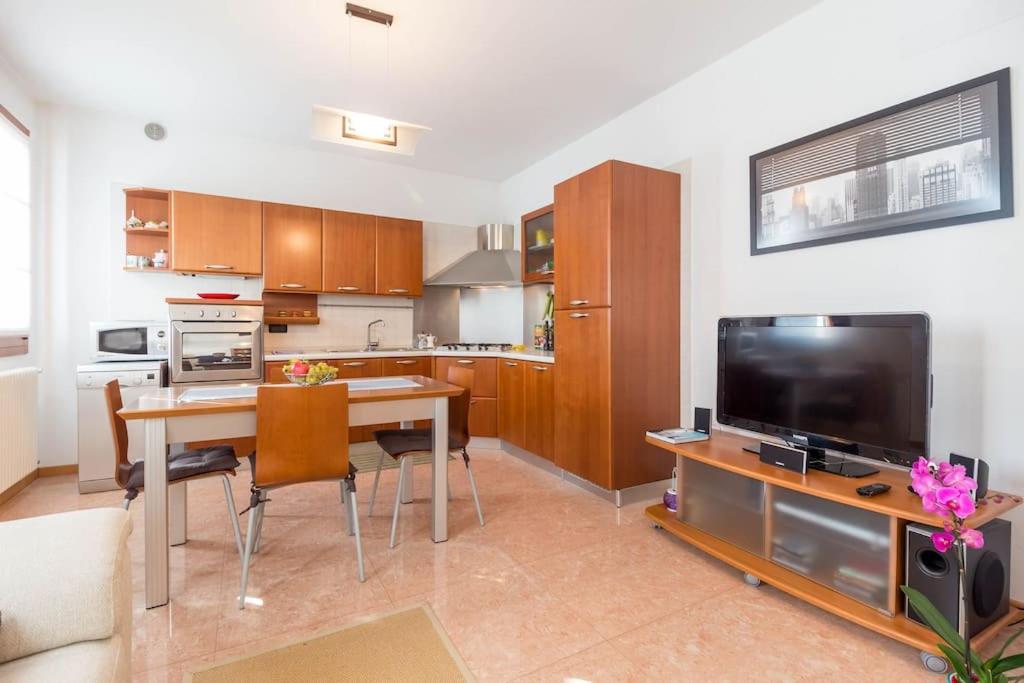 cocina con mesa de comedor y TV en Elegant apartment and free car parking - Quite area, en Favaro Veneto