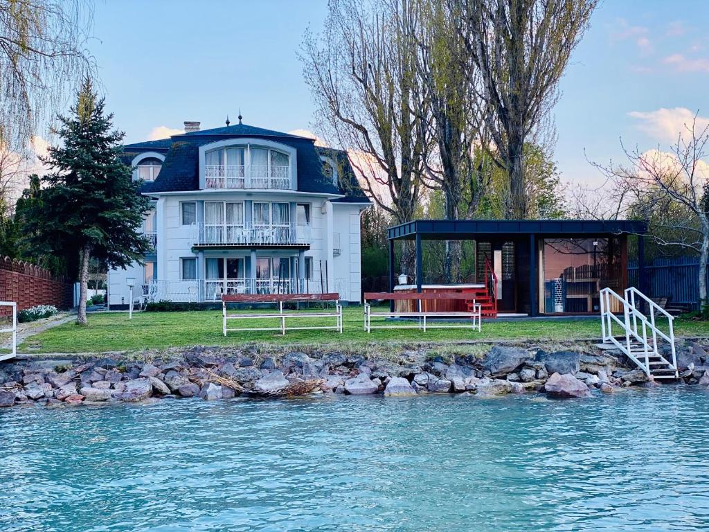 a house on the shore of a body of water at Villa My Lake in Zamárdi