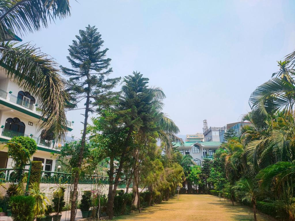a street with palm trees in front of a building at Panambi Tapovan Resort in Rishīkesh