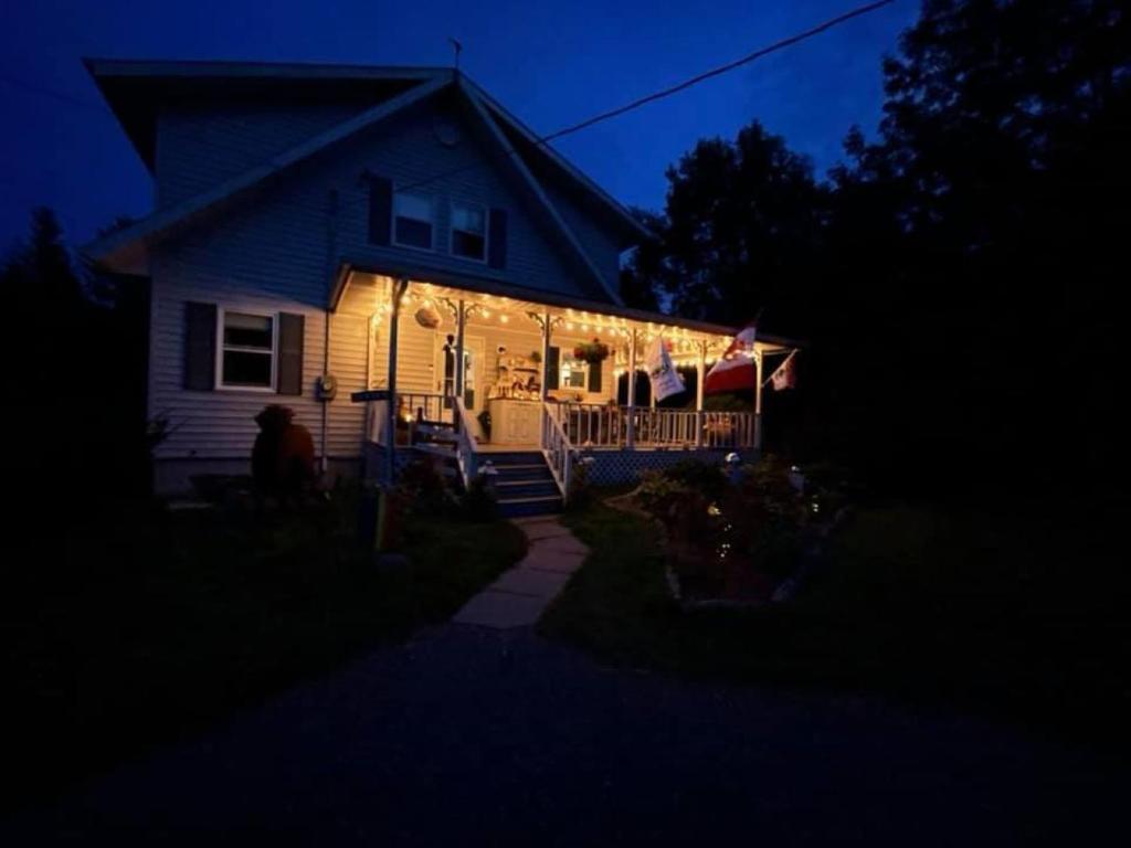 a house with lights on the front of it at night at Forest & Lake PEI Bed & Breakfast in Murray Harbour