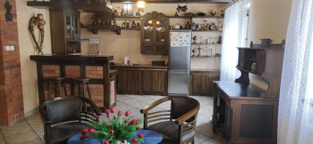 a kitchen with a refrigerator and a table and chairs at POKOJE GOŚCINNE MAJKA Apartament Stare jest Piękne in Mrągowo