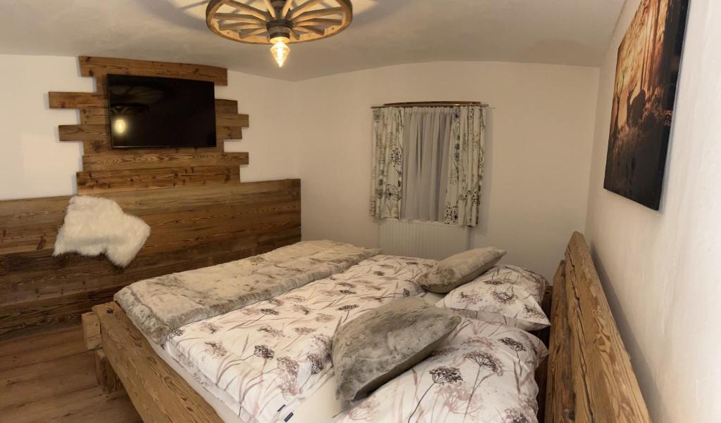 a bedroom with a bed and a flat screen tv at Gaisbergblick in Molln