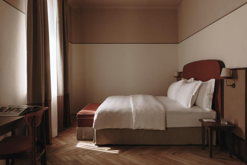 a hotel room with a bed and a window at Parkhotel Mondschein, a Member of Design Hotels in Bolzano