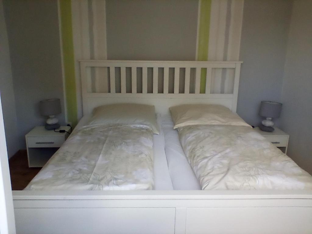 uma cama branca num quarto com duas mesas de cabeceira em Ferienwohnung Fritz em Groß Vollstedt
